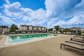Indianapolis townhouse for rent - A large outdoor swimming pool with sun loungers and a building in the background.