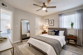 Bethany apartment for rent - A bedroom with a large bed, a ceiling fan, and a mirror.