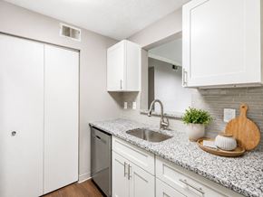 Georgetown apartment for rent - A kitchen with white cabinets and a granite countertop.