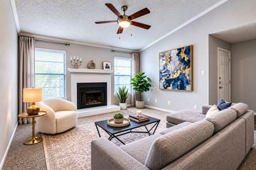 Bedford townhouse for rent - A living room with a grey couch, a fireplace, and a painting on the wall.