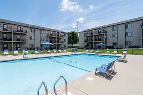 Rock Hill apartment for rent - A swimming pool surrounded by lounge chairs and apartment buildings.