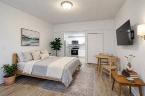 Stow apartment for rent - A bedroom with a bed, a table, and a television.