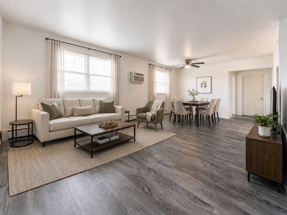 Lansdale apartment for rent - A living room with a white couch, a coffee table, and a dining table with chairs.