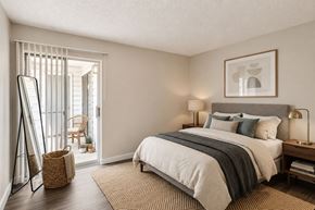 Bedford townhouse for rent - A bedroom with a large bed and a chair outside the window.