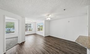 West Palm Beach apartment for rent - A spacious room with wood flooring and a ceiling fan.