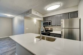 Oklahoma City apartment for rent - A kitchen with a white counter top and stainless steel appliances.