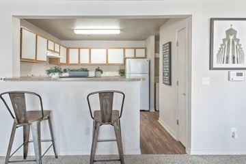 Owasso apartment for rent - Two chairs are placed in front of a kitchen island.