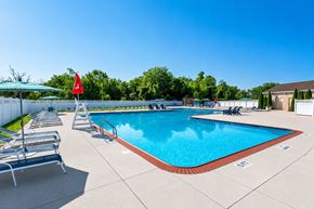 Horsham apartment for rent - A pool with a red flag and sun loungers.