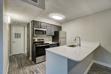 Oklahoma City apartment for rent - A kitchen with a white counter top and stainless steel appliances.