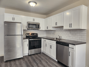 Horsham apartment for rent - A kitchen with white cabinets and a black countertop.