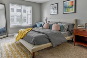 South Bend apartment for rent - A bedroom with a bed, a nightstand, and two framed pictures on the wall.