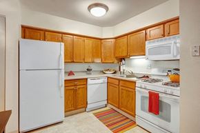 Elgin apartment for rent - a kitchen with white appliances and wooden cabinets