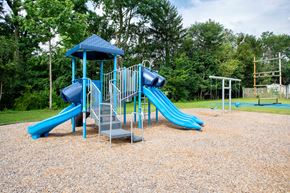 Horsham apartment for rent - A playground with a blue slide and a blue roofed structure.