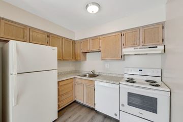 Horsham apartment for rent - a kitchen with white appliances and wooden cabinets