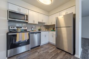 Quakertown apartment for rent - A kitchen with a stainless steel refrigerator, microwave, oven, and cabinets.