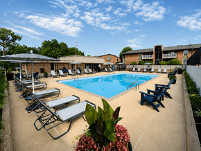Kettering apartment for rent - A pool surrounded by sun loungers and a building in the background.