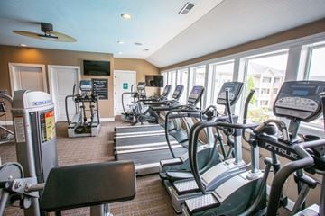 New Albany apartment for rent - a gym with various cardio equipment and windows