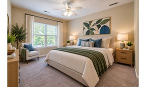 Mebane apartment for rent - A bedroom with a large bed and a ceiling fan.