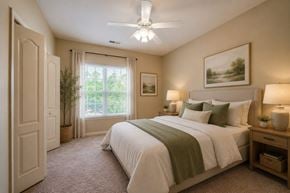 Mebane apartment for rent - A bedroom with a large bed and a ceiling fan.