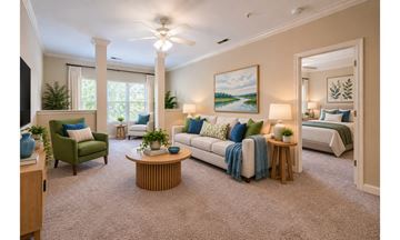 Mebane apartment for rent - A living room with a green chair, a white couch, and a painting on the wall.