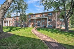 Carlisle apartment for rent - the front of a brick building with grass and trees