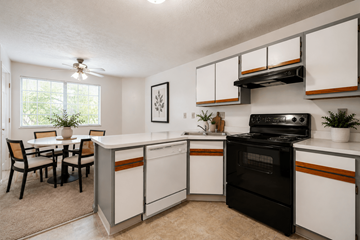 Cincinnati apartment for rent - A kitchen with black and white cabinets and a black stove top oven.