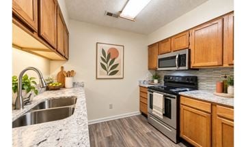 Fayetteville apartment for rent - A kitchen with wooden cabinets and a stainless steel oven.