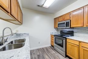 Fayetteville apartment for rent - A kitchen with wooden cabinets and a black stove top oven.
