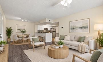 West Palm Beach apartment for rent - A living room with a white couch, a coffee table, and a painting on the wall.