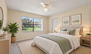 West Palm Beach apartment for rent - A bedroom with a large bed and a ceiling fan.