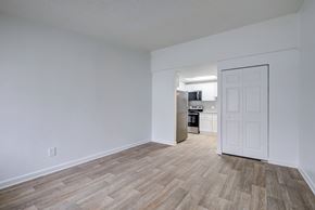 Hilliard apartment for rent - A kitchen with white walls and wooden flooring is visible through an open door.
