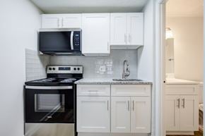 Jefferson Hills apartment for rent - A kitchen with black appliances and white cabinets.