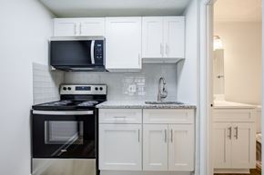 Ocala townhouse for rent - A kitchen with black appliances and white cabinets.