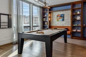 Chicago apartment for rent - A pool table in a room with a view of the city.