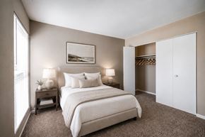 Kettering apartment for rent - A bedroom with a large bed and a painting on the wall.