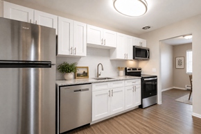 Webster apartment for rent - A modern kitchen with white cabinets and stainless steel appliances.