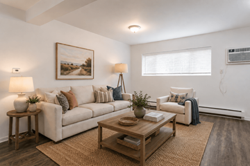 Webster apartment for rent - A living room with a white couch, a coffee table, and a painting on the wall.