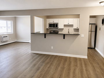 Webster apartment for rent - A kitchen with white cabinets and a wooden floor.