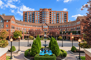 Louisville apartment for rent - A courtyard with a fountain surrounded by bushes and trees.