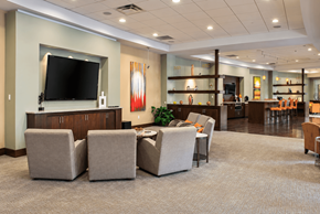 Louisville apartment for rent - A spacious waiting room with a television, comfortable seating, and a bar area.
