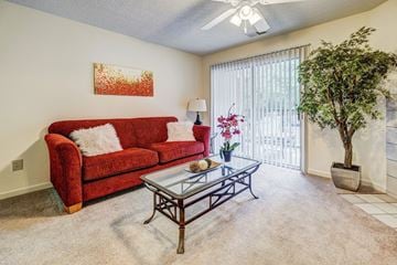 Fayetteville apartment for rent - a living room with a red couch and a glass coffee table