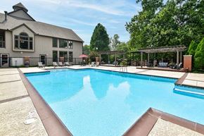 Louisville apartment for rent - A large swimming pool in front of a building with a covered area.
