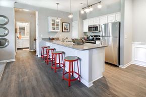Columbus townhouse for rent - A kitchen with a white counter and red stools.