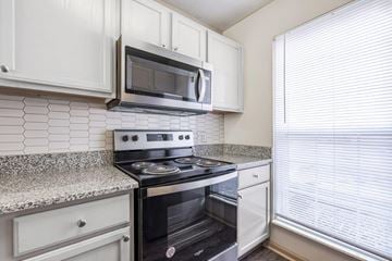Blacklick townhouse for rent - A kitchen with a black stove top oven and white cabinets.
