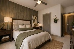 Greenville apartment for rent - A bedroom with a large bed and a ceiling fan.