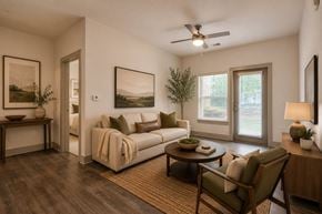 Greenville apartment for rent - A living room with a couch, chair, and a painting on the wall.
