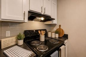 Huntersville apartment for rent - A kitchen with a black stove top and white cabinets.