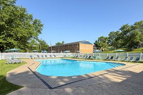 Allison Park apartment for rent - A pool surrounded by lawn chairs and trees.