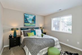 Indianapolis townhouse for rent - A bedroom with a bed, two lamps, and a painting on the wall.
