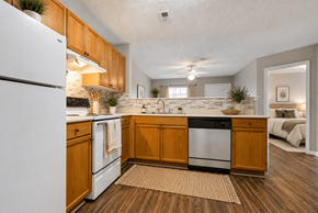 Kannapolis apartment for rent - A kitchen with wooden cabinets and a white refrigerator.